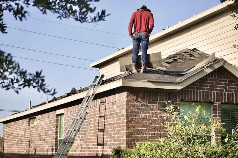 Professional roofer working on a residential roof in Gilman
